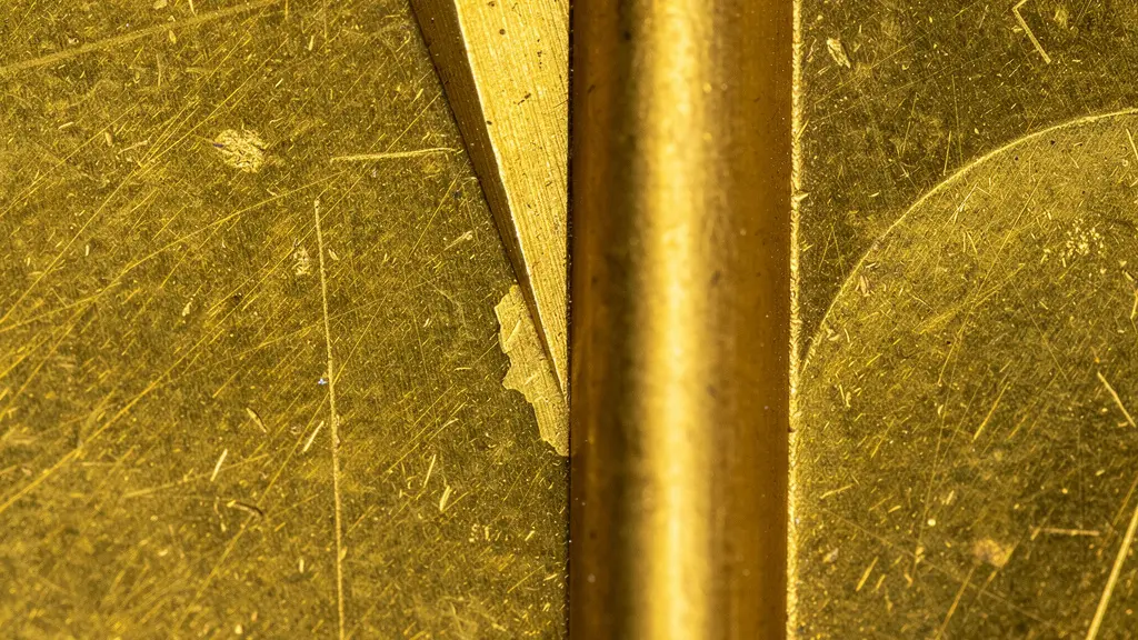 Coupe transversale microscopique montrant la différence entre sillon en V et sillon en U sur métal doré