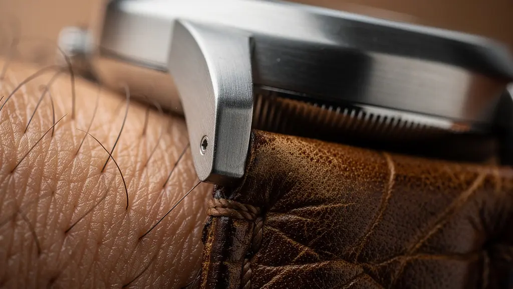 Gros plan macro sur une montre minimaliste au poignet montrant les détails de finition